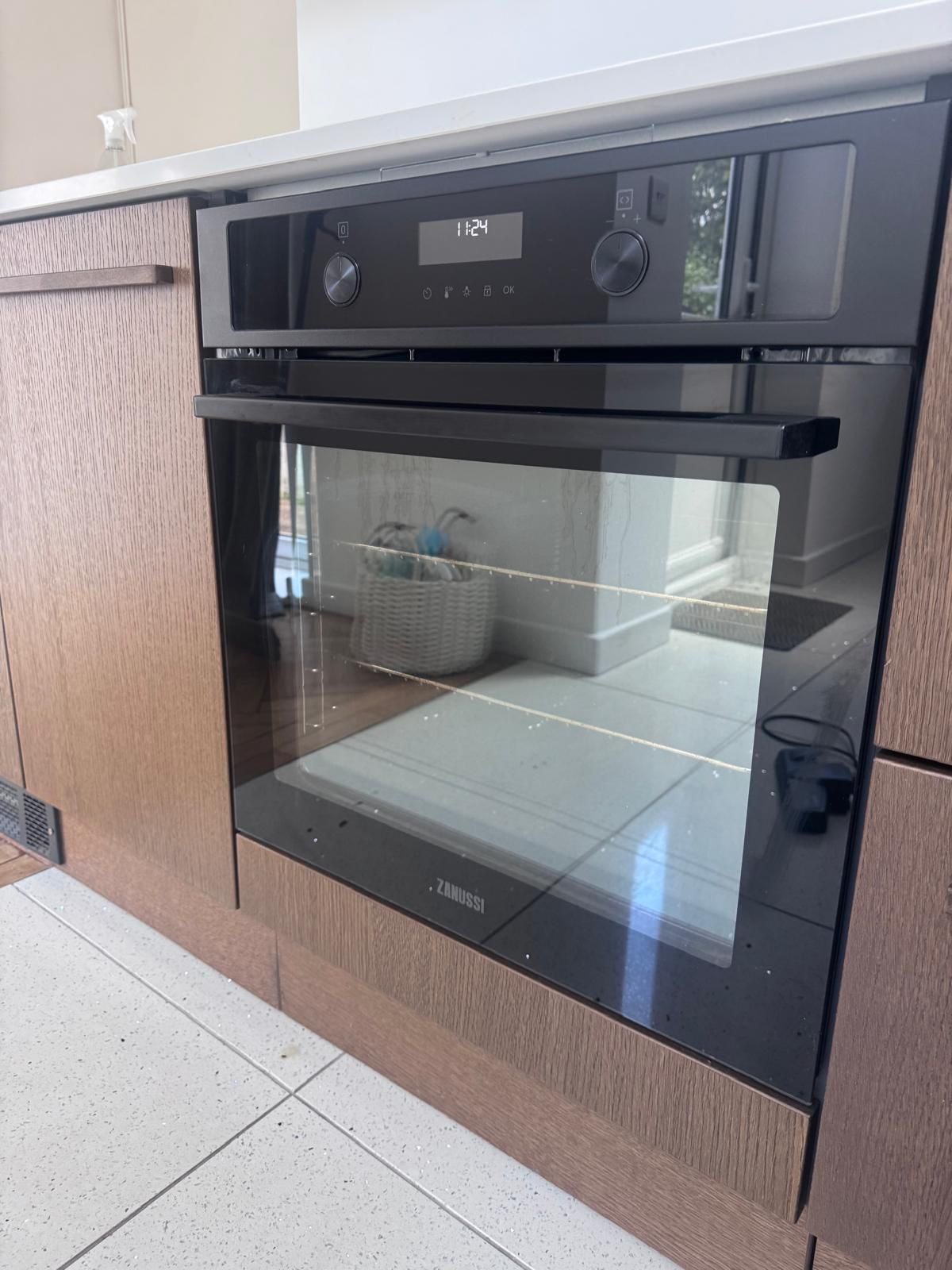 A freshly deep-cleaned built-in oven with a gleaming glass door